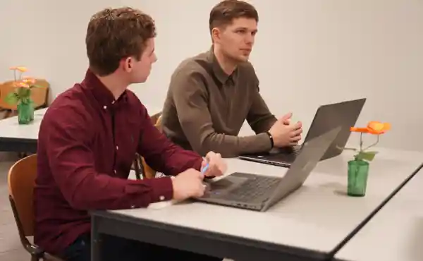 Student Consultant oprichter Reno Kochanowski in overleg aan tafel met young professional